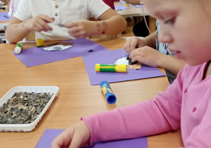 dzieci wyklejają jeża pestkami słonecznnika