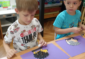 dzieci wyklejają jeża pestkami słonecznnika