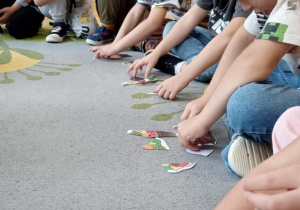dzieci układają puzzle na dywanie
