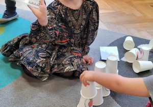 Dzieci układają jesienną wieżę z kubków wg wzoru