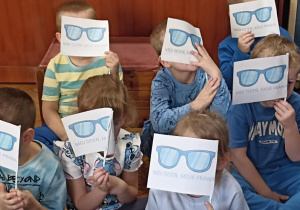 dzieci siedzą z flagami