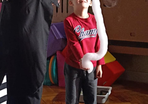 chłopiec stoi z bańkami mydlanymi
