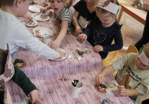 Dzieci wykonują jeże z ciasteczek