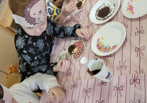 Dzieci wykonują jeże z ciasteczek