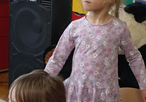 dziewczynka klęczy na krześle
