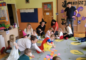 dzieci i rodzice siedzą na dywanie