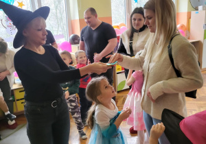 dzieci z rodzicami stoją na dywanie