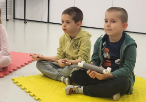 dzieci siedzą na macie