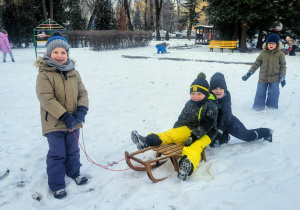 dzieci jadą na sankach