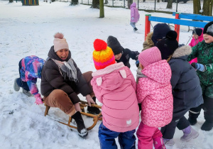 dzieci jadą na sankach
