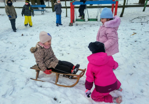 dzieci jadą na sankach
