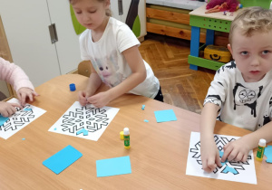 dzieci wyklejają papierem gwiazdkę