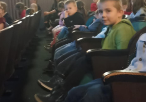 dzieci siedzą w teatrze