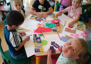 Dzieci wycinają i naklejają elementy na kartkę