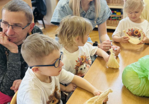 Dzieci z rodzicami wykonują koszyczki wielkanocne