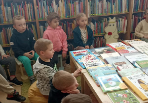 dzieci siedzą przy stole z książkami