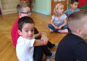 Dzieci siedzą na podłodze