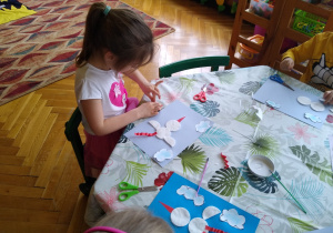Dziewczynka wykonuje pracę plastyczną