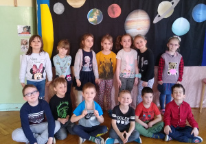 Dzieci pozują na tle planet