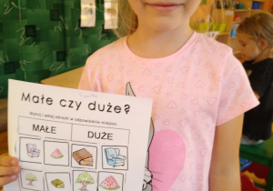 Dziewczynka pozuje z kartką