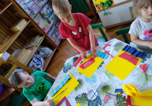 Dzieci przyklejają kolorowe kawałki papieru