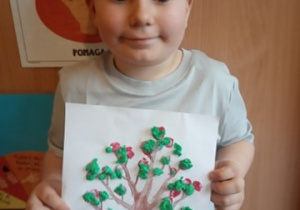Chłopiec prezentuje swoją pracę.