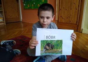 Chłopiec prezentuje swoją pracę