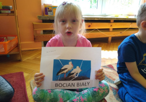 Dziewczynka prezentuje swoją pracę