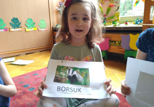 Dziewczynka prezentuje swoją pracę