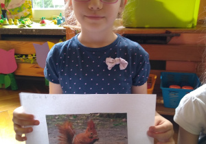 Dziewczynka prezentuje swoją pracę