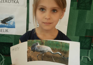 Dziewczynka prezentuje swoją pracę