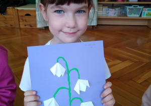 Dziewczynka prezentuje swoją pracę