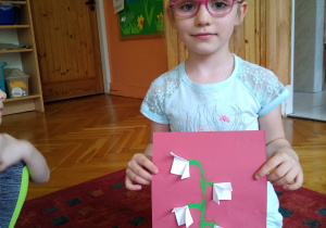 Dziewczynka prezentuje swoją pracę