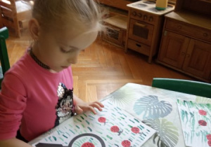 Dziewczynka wykonuje pracę plastyczną.