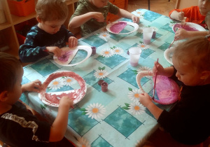 dzieci malują papierowe taterzyki wycięte w kształcie koszyka