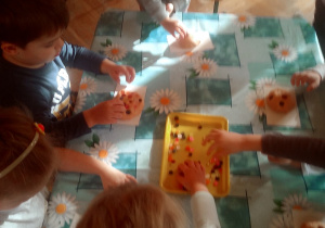 dzieci lepią z masy solnej bułki i rogale i ozdabiają je guziczkami