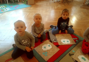 dzieci na dywanie układają kropelki wycięte z papieru kolorowego