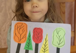Dziewczynka prezentuje swą pracę "Park jesienią".