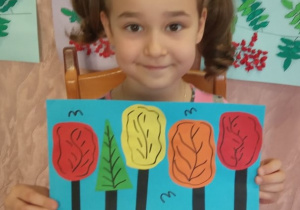 Dziewczynka prezentuje swą pracę "Park jesienią".
