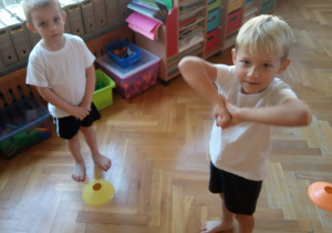 Dzieci ćwiczą szybką orientację w przestrzeni z wykorzystaniem pachołków "grzybków".