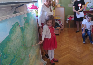 Dziewczynka pokazuje na mapie Warszawę