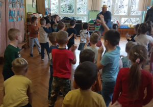 Dzieci śpiewają i tańczą razem z panem prowadzącym zabawy muzyczne.