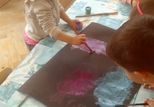 dzieci malują czarny karton farbami