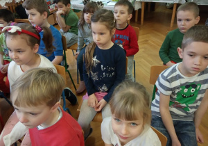 Dzieci z grupy V przysłuchują się muzykom.