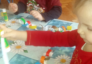 dzieci sklejają paski z kolorowego papieru