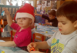 dzieci sklejają paski z kolorowego papieru