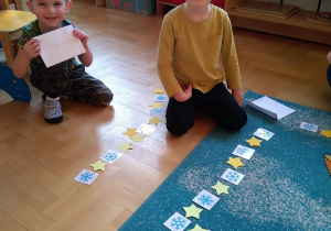 Chłopiec układa sekwencje z kartoników z gwiazdkami i śnieżynkami