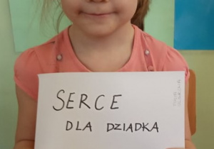 Dziewczynka prezentuje swoje serduszko dla Dziadka.