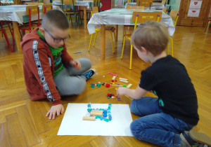 Dzieci układają roboty z klocków, patyczków, kamyczków itp.
