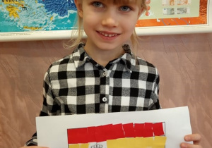 Dziewczynka prezentuje flagę Hiszpanii.